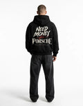 Model wearing black Porsche-inspired graphic hoodie with distressed cream typography and red script back print