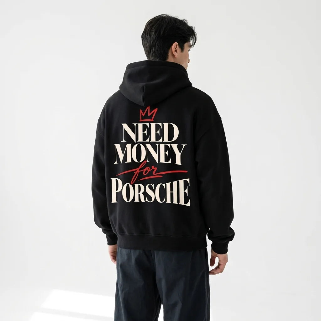 Model wearing a black Porsche-inspired typography hoodie with large cream lettering and a red hand-drawn crown back print