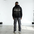 Model wearing black Need Money for Porsche hoodie with classic serif typography and detailed sports car line art on the back