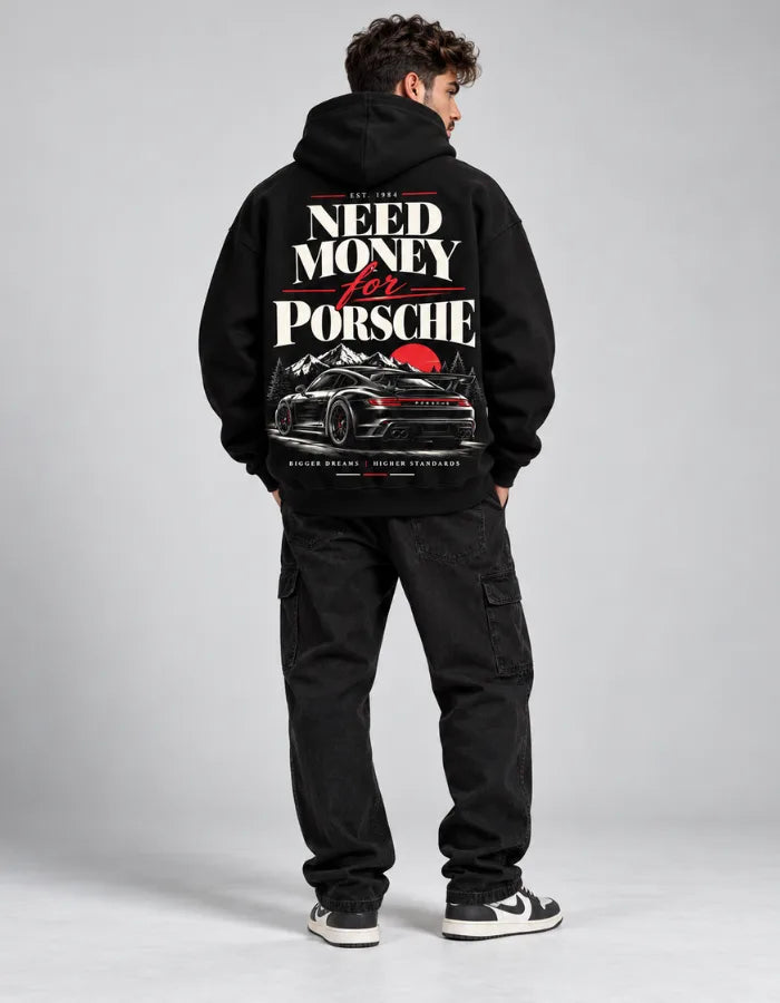 Male model wearing black Need Money for Porsche hoodie with mountain sunset car graphic on the back