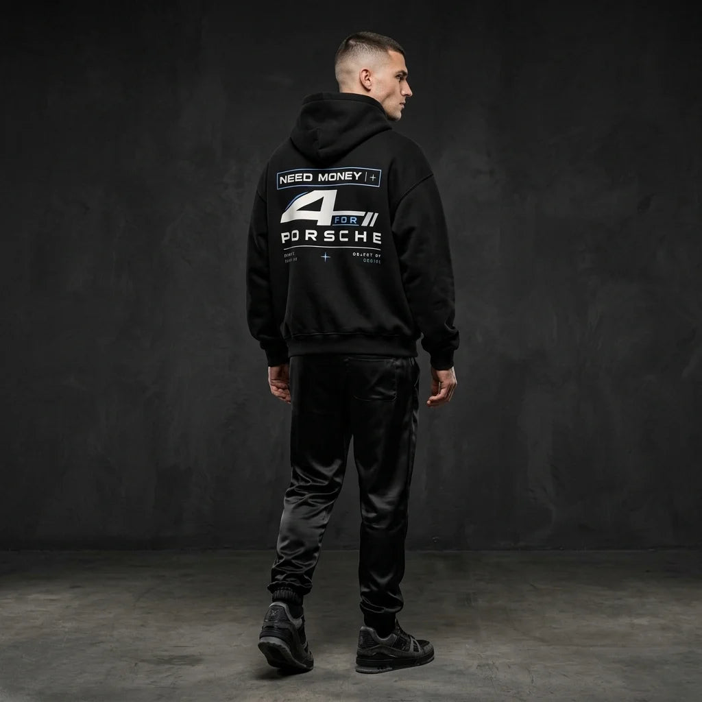 Model wearing a black Porsche graphic hoodie from behind, showing a large stylized number 4, white typography and subtle blue racing accents