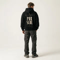 Model wearing a black Need Money for Porsche graphic hoodie with tall split serif lettering and two muted gold star accents on the back