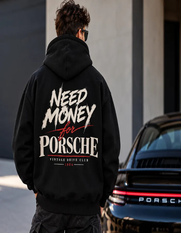 Male model wearing a black Need Money for Porsche hoodie with cream brush lettering and red script back print